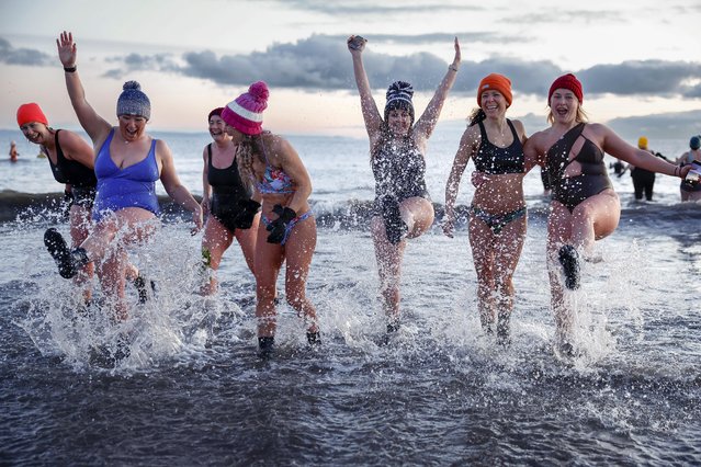 Hundreds of swimmers took a sunrise dip in the North Sea at Portobello Beach, for the International Women’s Day on March 08, 2023 in Edinburgh, Scotland. The event was organised as a fundraiser for Women's Aid, which aims to end domestic violence against women and children. (Photo by Jeff J. Mitchell/Getty Images)