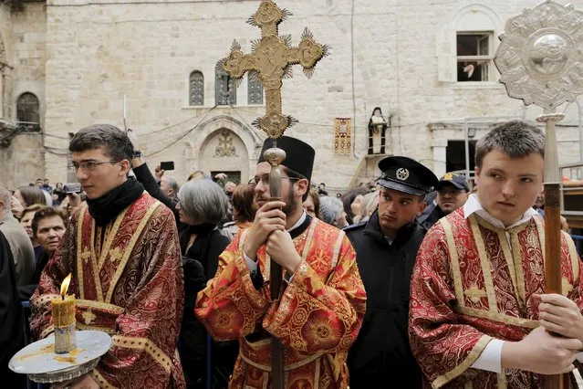 Members of the Greek Orthodox clergy await the arrival of the Greek Orthodox Patriarch of Jerusalem Metropolitan Theophilos before the washing of the feet ceremony outside the Church of the Holy Sepulchre in Jerusalem's Old City, April 9, 2015, ahead of Orthodox Easter. (Photo by Ammar Awad/Reuters)