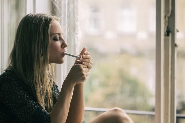 Young woman smoking cigarette. (Photo by Peter Zelei Images/Getty Images)