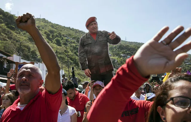 Government supporters hold a life-size image of Venezuela's late President Hugo Chavez during a rally in La Guaira, Venezuela, Friday, January 25, 2019. Venezuelan President Nicolas Maduro, Chavez's protege, says he's willing to engage in talks with the opposition in order to avoid violence in a conflict over who is the legitimate leader of the country. (Photo by Rodrigo Abd/AP Photo)