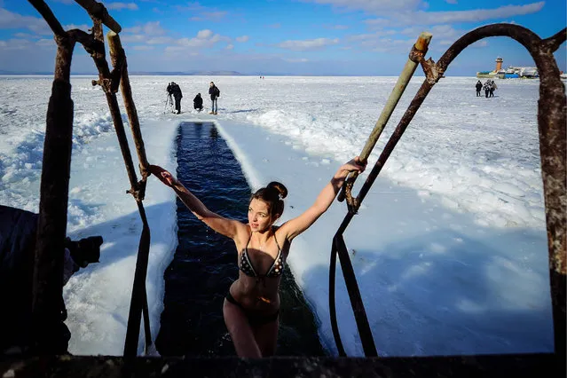 A member of the “Morzh” (Walrus) winter swimming club emerges from an ice hole after a swim in Vladivostok, Russia on January 15, 2017. (Photo by Yuri Smityuk/TASS)