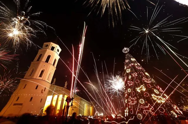 Fireworks light the sky above Cathedral Square in Vilnius, Lithuania. (Photo by Mindaugas Kulbis/Associated Press)