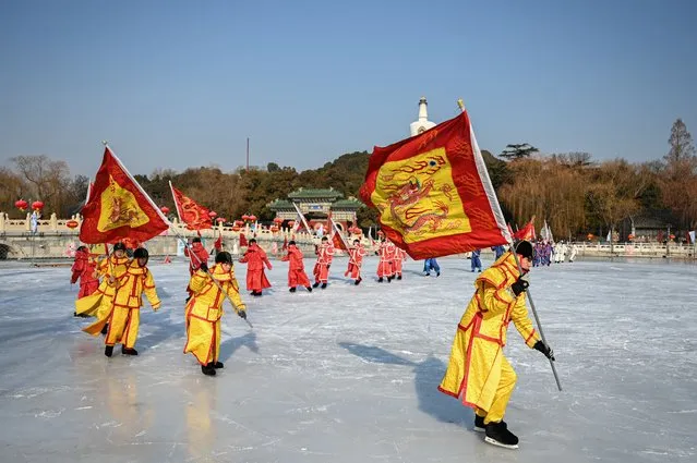Actors dressed as imperial soldiers perform “ice play”, one of the traditional ice sports of the royal family during the Qing Dynasty, on a frozen lake at Beihai Park in Beijing on December 29, 2023. (Photo by Jade Gao/AFP Photo)