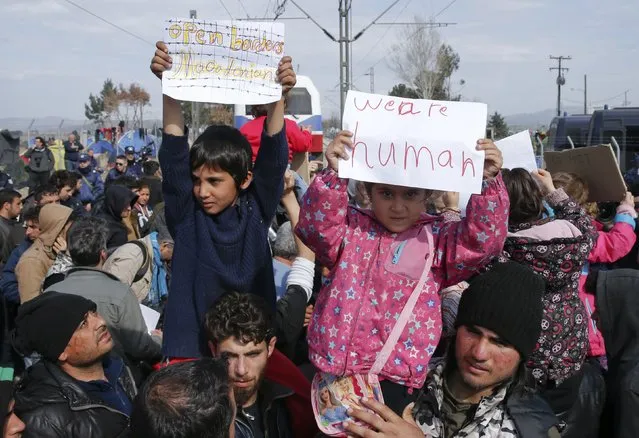 Migrant children hold posters as they block the railway track at the Greek-Macedonian border, near the village of Idomeni, Greece March 3, 2016. (Photo by Marko Djurica/Reuters)