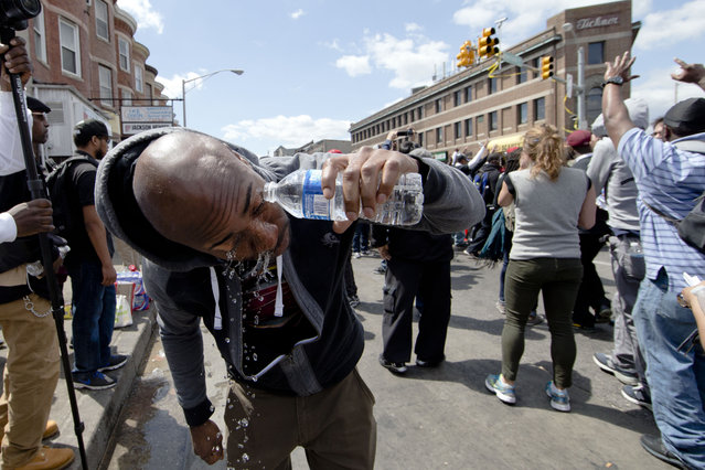 A man rinses his eyes after he was sprayed by police with a crowd dispersant Tuesday, April 28, 2015, in Baltimore, in the aftermath of rioting following Monday's funeral for Freddie Gray, who died in police custody. (Photo by Matt Rourke/AP Photo)