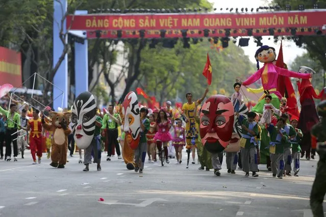 A group of artists of traditional performances and circus take part in a parade celebrating the 40th anniversary of the end of the Vietnam War which is also remembered as the fall of Saigon, in Ho Chi Minh City, Vietnam, Thursday, April 30, 2015. (Photo by Na Son Nguyen/AP Photo)