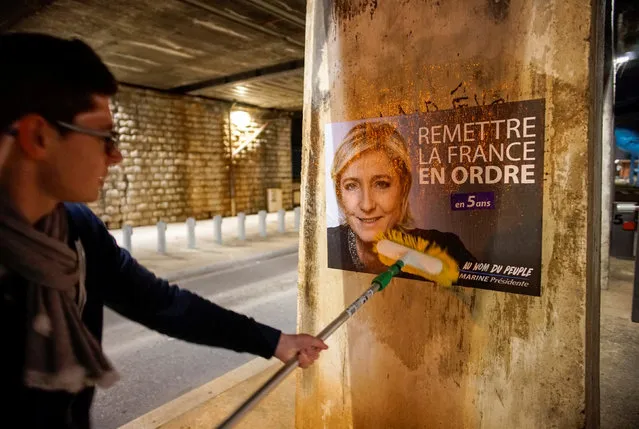 A member of the National Front youths puts up a poster of Marine Le Pen, French National Front (FN) political party leader and candidate for the French 2017 presidential election, ahead of a 2-day FN political rally to launch the presidential campaign in Lyon, France, February 2, 2017. (Photo by Robert Pratta/Reuters)