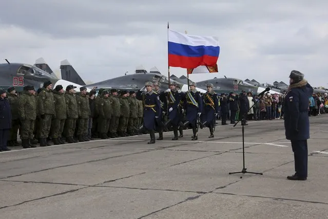 Participants attend a ceremony to welcome Russian military jets and pilots upon their return to a home airbase from Syria, in Buturlinovka in Voronezh region, Russia, March 15, 2016. (Photo by Olga Balashova/Reuters/Russian Ministry of Defence)