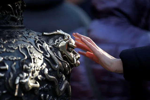 A woman touches a statue of a dragon for good fortune on the fifth day of the Chinese Lunar New Year at Baiyun Temple in Beijing, China, February 1, 2017. (Photo by Jason Lee/Reuters)