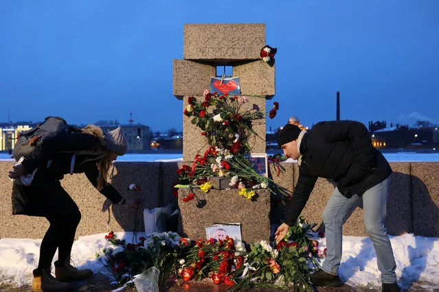 People lay flowers at the monument to the victims of political repressions following the death of Russian opposition leader Alexei Navalny in Saint Petersburg, Russia on February 16, 2024. (Photo by Reuters/Stringer)