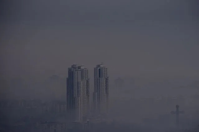 A building is seen through the heavy fog and air pollution that cover the Skopje valley in the early morning in Skopje, Republic of North Macedonia, 02 January 2024. The Air Quality Index (AQI) this morning is 164, which is labeled as 'unhealthy', making the capital city one of the most polluted in the world, according to IQAir, a Swiss air quality technology company. The levels of toxic PM10 and PM2.5 particles in the air measured by IQAir in Skopje on 02 January were about 10 times higher than the safety threshold established by the World Health Organization. (Photo by Georgi Licovski/EPA/EFE)