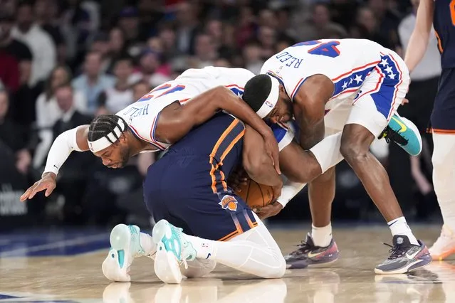 Philadelphia 76ers guard Buddy Hield (17) and forward Paul Reed (44) and New York Knicks forward Precious Achiuwa try to get control of the ball during the first half of an NBA basketball game Tuesday, March 12, 2024, at Madison Square Garden in New York. (Photo by Mary Altaffer/AP Photo)