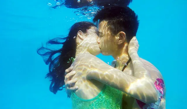 A couple kiss underwater during an underwater kissing contest at Wuhan Playa Maya Water Park on August 2, 2015 in Wuhan, China. 11 couples joined an underwater kissing contest at Wuhan Playa Maya Water Park on Sunday. A couple married for 11 year won the prize in a time of 1.02 minute. (Photo by ChinaFotoPress/ChinaFotoPress via Getty Images)