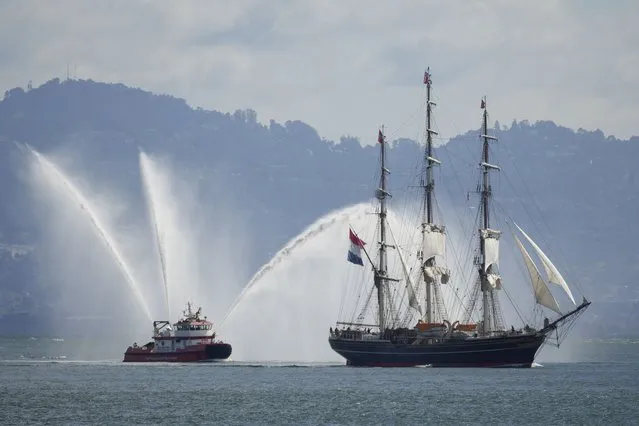 The Dutch tall ship Stad Amsterdam makes its way through San Francisco Bay followed by the fireboat St. Francis in this view from Sausalito, Calif., Sunday, March 24, 2024. The ship is sailing for Honolulu and then Tokyo, continuing on its world tour. (Photo by Eric Risberg/AP Photo)