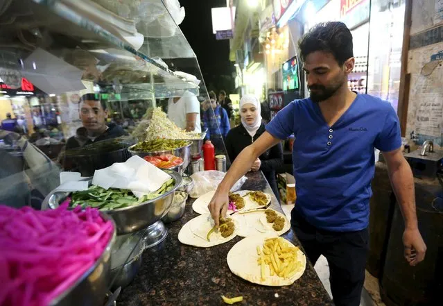 Syrians work at a Syrian restaurant in an area called 6 October City in Giza, Egypt, March 19, 2016. Attracting visitors from across the country, a market mostly run by Syrians fleeing the war has recently gained popularity in Giza. The area, in 6 October City, is known as “Little Damascus” due to its large Syrian population, as well as eateries and shops selling traditional Syrian delicacies. (Photo by Mohamed Abd El Ghany/Reuters)