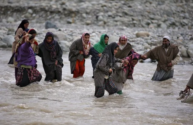 Kashmiri Muslims cross a stream to attend the funeral of Waseem Ahmad Malla, a suspected militant, in Pehlipora village in Shopian district in south Kashmir April 7, 2016. Two suspected militants, one of whom was Malla, were killed during a gunbattle with Indian security forces in Shopian early Thursday, local media reported. (Photo by Danish Ismail/Reuters)