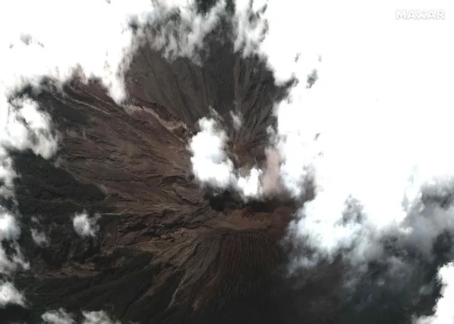 This handout satellite image released by Maxar Technologies shows the summit of Mount Semeru visible through a ring of clouds on December 8, 2021. The death toll from the eruption of Indonesia's Mount Semeru has risen to 39, authorities said Wednesday, as rescuers scrambled to retrieve more bodies under the threat of further volcanic activity. (Photo by Satellite image 2021 Maxar Technologies/AFP Photo)