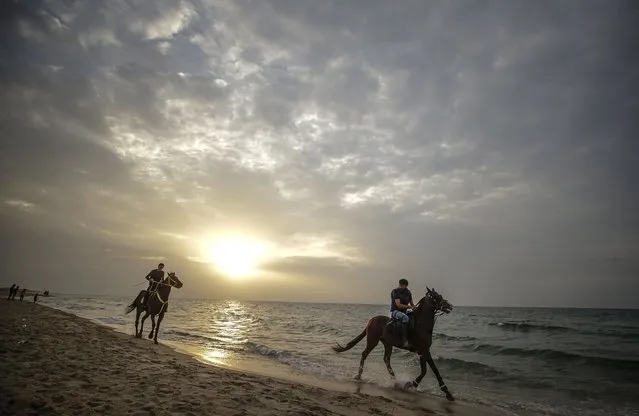 Palestinian men ride their horses on the beach at sunset in the northern Gaza City, 18 Novemebr 2021. (Photo by Mohammed Saber/EPA/EFE)