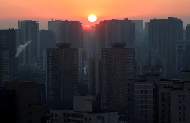 The sun rises in a neighborhood ahead of the Beijing 2022 Winter Olympics in Beijing, China on January 6, 2022. (Photo by Fabrizio Bensch/Reuters)