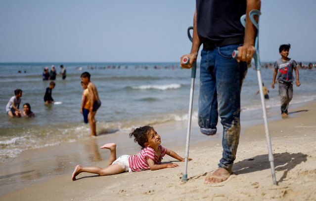 A child looks on as Palestinians enjoy the beach on a hot day, amid the ongoing conflict between Israel and Hamas, in Rafah, in the southern Gaza Strip, on April 24, 2024. (Photo by Mohammed Salem/Reuters)