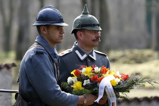 A French, left, and a German member of World War I historical associations lay a wreath for soldiers from both sides who were killed near Bezonvaux. (Photo by Charles Platiau/Reuters)