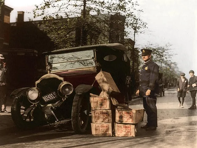Policeman standing alongside wrecked car and cases of moonshine, 16th November 1922. (Photo by Tom Marshall/Mediadrumworld)