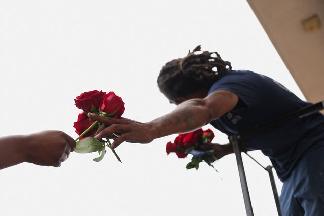 A family member hands roses to be placed with the casket of U.S. Airman Roger Fortson to the cemetery burial team during the graveside service at Lincoln Cemetery in Atlanta, Georgia, on May 17, 2024. (Photo by Alyssa Pointer/Reuters)