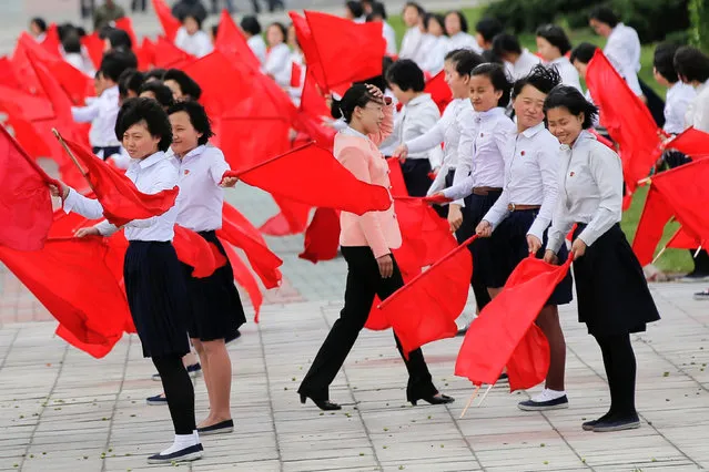 Strong wind blows as girls practice dancing with red flags in central Pyongyang, North Korea May 4, 2016. (Photo by Damir Sagolj/Reuters)