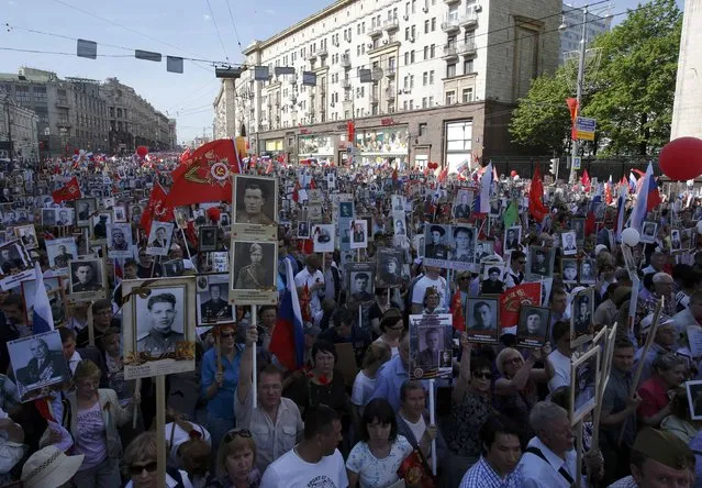People hold pictures of World War Two soldiers as they take part in the Immortal Regiment march during the Victory Day celebrations, marking the 71st anniversary of the victory over Nazi Germany in World War Two, in central Moscow, Russia, May 9, 2016. (Photo by Sergei Karpukhin/Reuters)