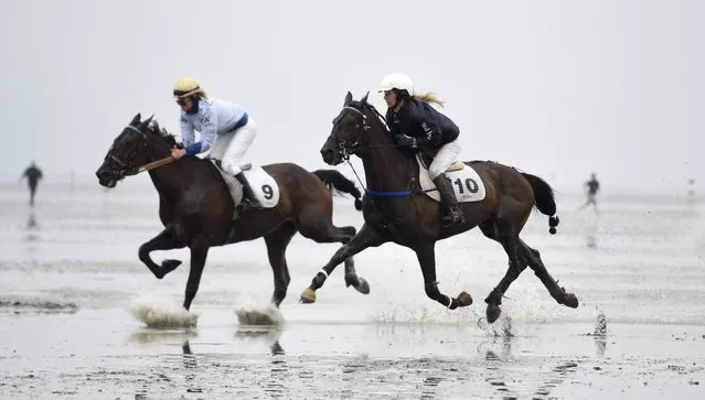 Jockeys ride horses on mud flats during their tideland race (Wadden Race) in Duhnen, Lower Saxony, Germany, July 12, 2015. (Photo by Fabian Bimmer/Reuters)