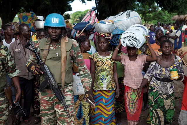 A Cameroonian United Nations peacekeeping soldier guards women fleeing the village of Zike as they arrive to the village of Bambara, Central African Republic, April 25, 2017. (Photo by Baz Ratner/Reuters)