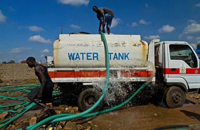 A water pipe comes loose from a mobile water tank in Juba, South Sudan, on September 19th 2012. The water distribution in Juba is carried out via mobile water tanks which transport unfiltered water directly from the river Nile. (Photo by Camille Lepage/AFP Photo)