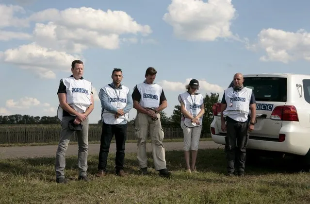 Members of the Organisation for Security and Co-operation in Europe (OSCE) observe a minute of silence at the site of the Malaysia Airlines flight MH17 plane crash near the village of Hrabove in Donetsk region, Ukraine, July 17, 2015. (Photo by Kazbek Basaev/Reuters)