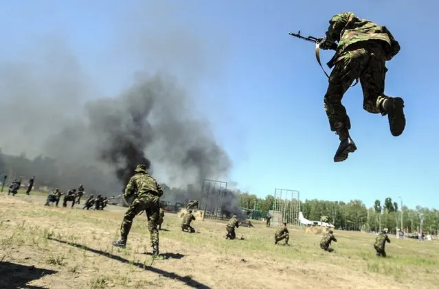This handout picture taken and released by the Prime Minister press service on May 22, 2014 shows Ukrainian National guard troops taking part in an exercise in presence of acting Ukrainian Prime Minister on the shooting range not far from Kiev. Rebels firing mortar shells and grenades killed 14 Ukrainian soldiers today, the blackest day for the military in its fight against a pro-Russian insurgency, dramatically heightening tensions just three days before a crunch election. (Photo by Andrew Kravchenko/AFP Photo)