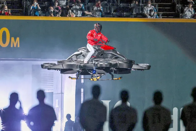 This picture taken on March 29, 2022 shows Tsuyoshi Shinjo, the newly appointed manager of the Hokkaido Nippon Ham Fighters and former Major League Baseball (MLB) player in the US, entering the stadium by flying through the air on a hover-bike before the start of their Japanese pro-baseball season opening game against the Seibu Lions at the Sapporo Dome in Sapporo, Hokkaido prefecture. The 50-year-old's theatrics have been front-page material in Japan's sports newspapers since he was appointed late last year, and his latest antics made another big splash. (Photo by JIJI Press/AFP Photo)