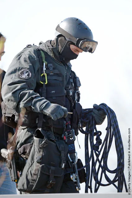 A Member of Germany's elite police unit, the Spezialeinsatzkommando, or SEK, packs up his equipment after demonstrating an abseil deployment from a helicopter during a media event
