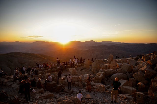 People watch the sunset as they gather at the archaeological site of massive stone head sculptures on Mount Nemrut in Ad?yaman, southeastern Turkey, on August 11, 2024, the night of the Perseid meteor shower. The Perseid meteor shower took place on the night between August 10-11, above the 2,134-meter-density mountain, a UNESCO World Heritage Site since 1987, which features giant 10-meter statues of King Antiochus I, surrounded by ancient gods, including Zeus and Apollo, discovered by a German engineer in 1881. (Photo by Kemal Aslan/AFP Photo)