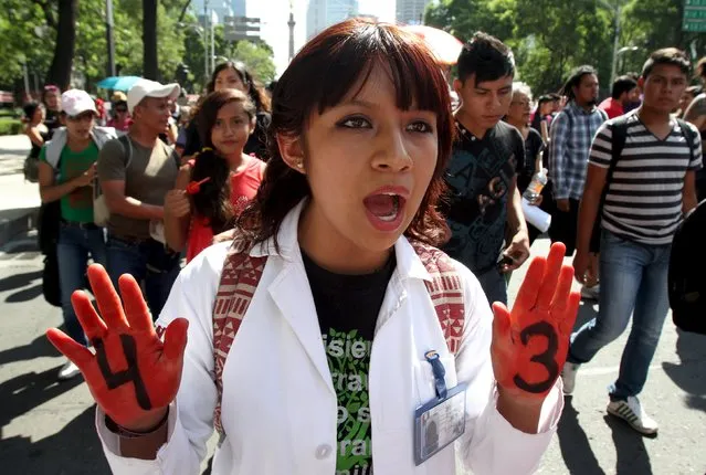 A demonstrator, with a 4 and a 3 written on the palm of her hands, takes part in a march to mark the ten-month anniversary of the Ayotzinapa students' disappearance, in Mexico City, Mexico, July 26, 2015. An independent Mexican commission said on Thursday, it found serious flaws in the investigation into the apparent massacre of 43 students last year, dealing a fresh blow to President Enrique Pena Nieto over a scandal that has battered his administration. (Photo by Reuters/Stringer)