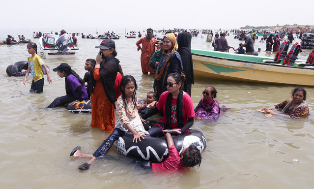 Visitors cool off on a hot summer afternoon in Keenjhar lake, in Thatta district, Sindh province on June 23, 2024. (Photo by Akram Shahid/AFP Photo)