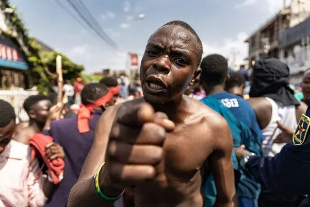 A demonstrator gestures as with others tries to reach the border between Democratic Republic of Congo and Rwanda during a protest in Goma on June 15, 2022. Several thousand people demonstrated on Wednesday in Goma, on the border with Rwanda, in the east of the Democratic Republic of Congo (DRC), to denounce “Rwandan aggression” and express their support for the Congolese army, in a context of maximum tension between Kinshasa and Kigali. (Photo by Michel Lunanga/AFP Photo)