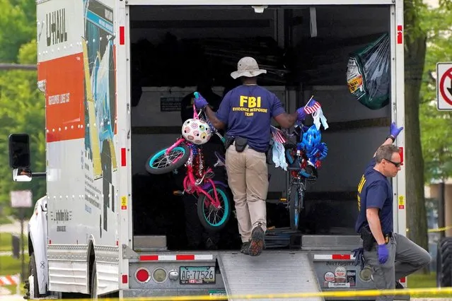 FBI agents clear abandoned children’s bikes from the scene after a mass shooting at a Fourth of July parade in the Chicago suburb of Highland Park, Illinois, U.S., July 7, 2022. (Photo by Cheney Orr/Reuters)