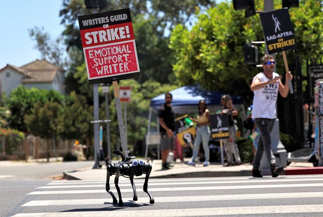 A robot dog named Gato moves with a sign on it as SAG-AFTRA actors and Writers Guild of America (WGA) writers walk the picket line during their ongoing strike outside Paramount Studios in Los Angeles, California, U.S., August 2, 2023. (Photo by Mario Anzuoni/Reuters)