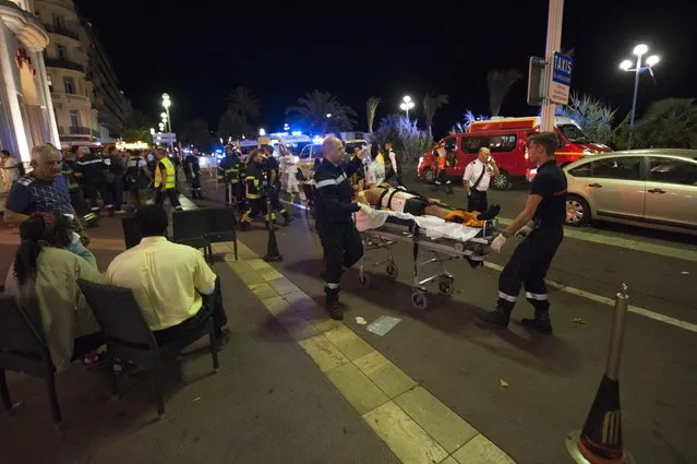 Wounded people are evacuated from the scene where a truck crashed into the crowd during the Bastille Day celebrations in Nice, France, 14 July 2016. (Photo by Olivier Anrigo/EPA)