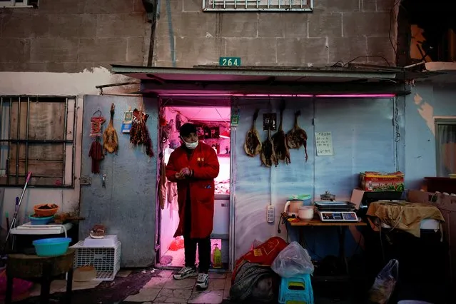 A man wears a protective face mask at a butcher shop following an outbreak of coronavirus disease (COVID-19), in downtown Shanghai, China on March 16, 2020. (Photo by Aly Song/Reuters)