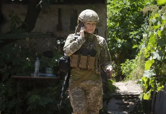 Ukrainian platoon commander Mariia talks on the phone in a position in the Donetsk region, Ukraine, Saturday, July 2, 2022. Ukrainian soldiers returning from the frontlines in eastern Ukraine’s Donbas region describe life during what has turned into a grueling war of attrition as apocalyptic. Mariia, 41, said that front-line conditions may vary depending on where a unit is positioned and how well supplied they are. (Photo by Efrem Lukatsky/AP Photo)