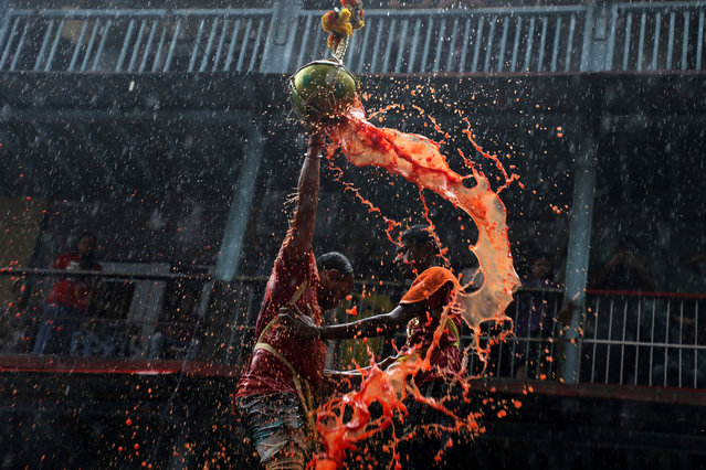 A devotee breaks a clay pot containing curd during celebrations to mark the Hindu festival of Janmashtami in Mumbai, India on September 7, 2023. (Photo by NIharika Kulkarni/Reuters)