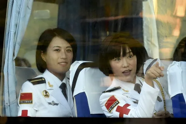 A female soldier of the People's Liberation Army (PLA) of China gestures to her fellow comrade on a bus upon their arrival ahead of a military parade to mark the 70th anniversary of the end of World War Two, in Beijing, China, September 3, 2015. (Photo by Reuters/Stringer)