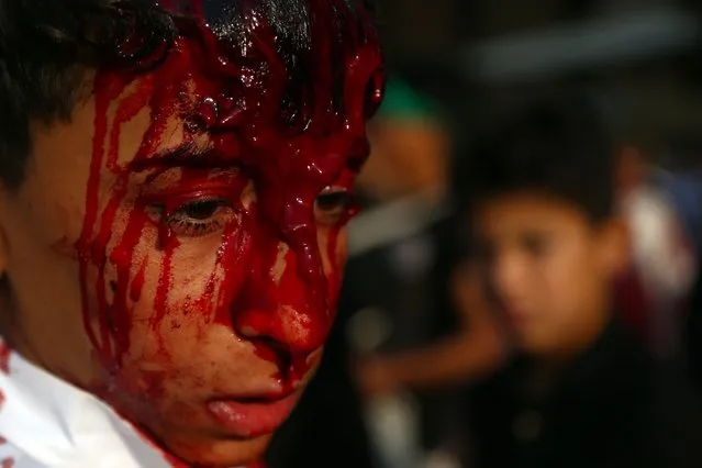 An Iraqi Shiite Muslim boy looks on as he takes part in a traditional mourning event during Ashura commemorations that mark the killing of Imam Hussein, one of Shiite Islam's most revered figures, early October 1, 2017 in the holy city of Najaf. (Photo by Haidar Hamdani/AFP Photo)