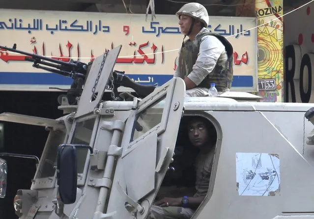 Army soldiers stand guard in their military vehicle in central Cairo ahead of expected protests, August 30, 2014. (Photo by Asmaa Waguih/Reuters)