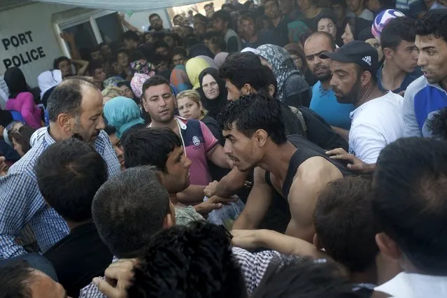 Afghan and Syrian refugees scuffle over priority for a registration procedure at the port of Mytilene on the Greek island of Lesbos, September 6, 2015. (Photo by Dimitris Michalakis/Reuters)